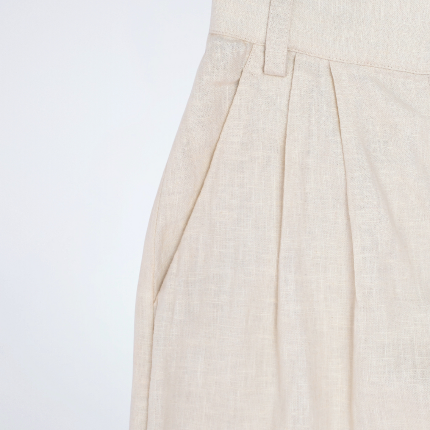 Pearl white linen pants with soft pleats and a stretch waist. Lightweight, breathable, and roomy for comfort and movement