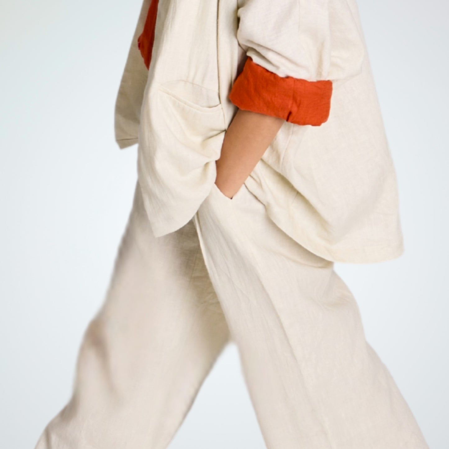 Pearl white linen pants with soft pleats and a stretch waist. Lightweight, breathable, and roomy for comfort and movement
