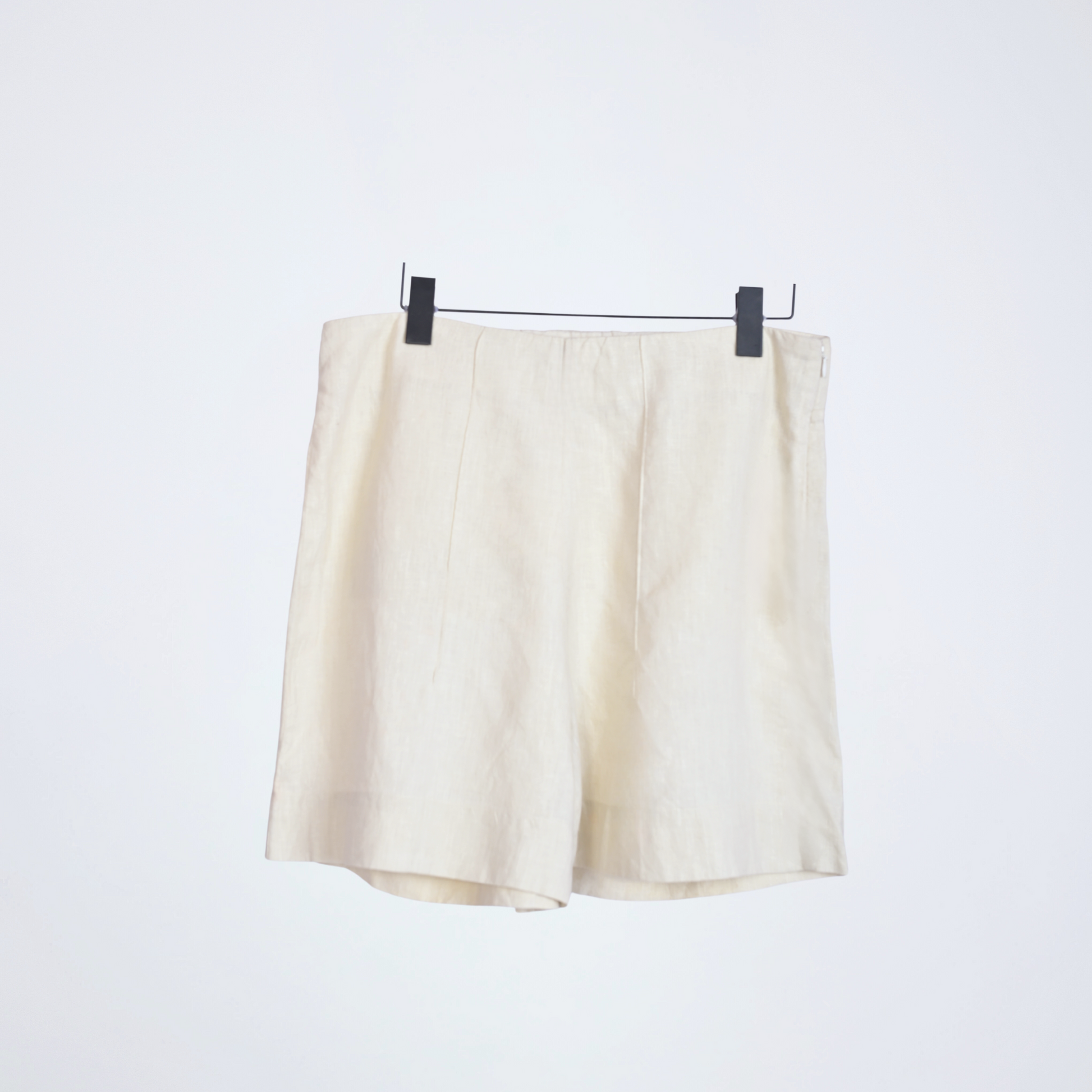 Pearl white linen shorts with crisp structure and side-zip. Breathable, mid-rise, and versatile, it adapts to your day