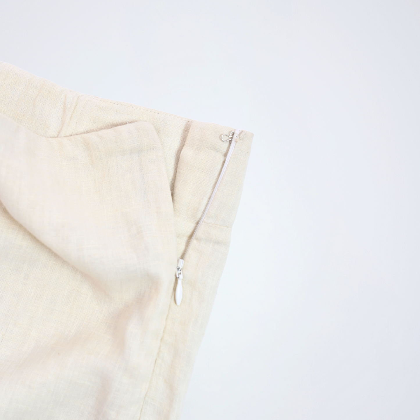 Pearl white linen shorts with crisp structure and side-zip. Breathable, mid-rise, and versatile, it adapts to your day