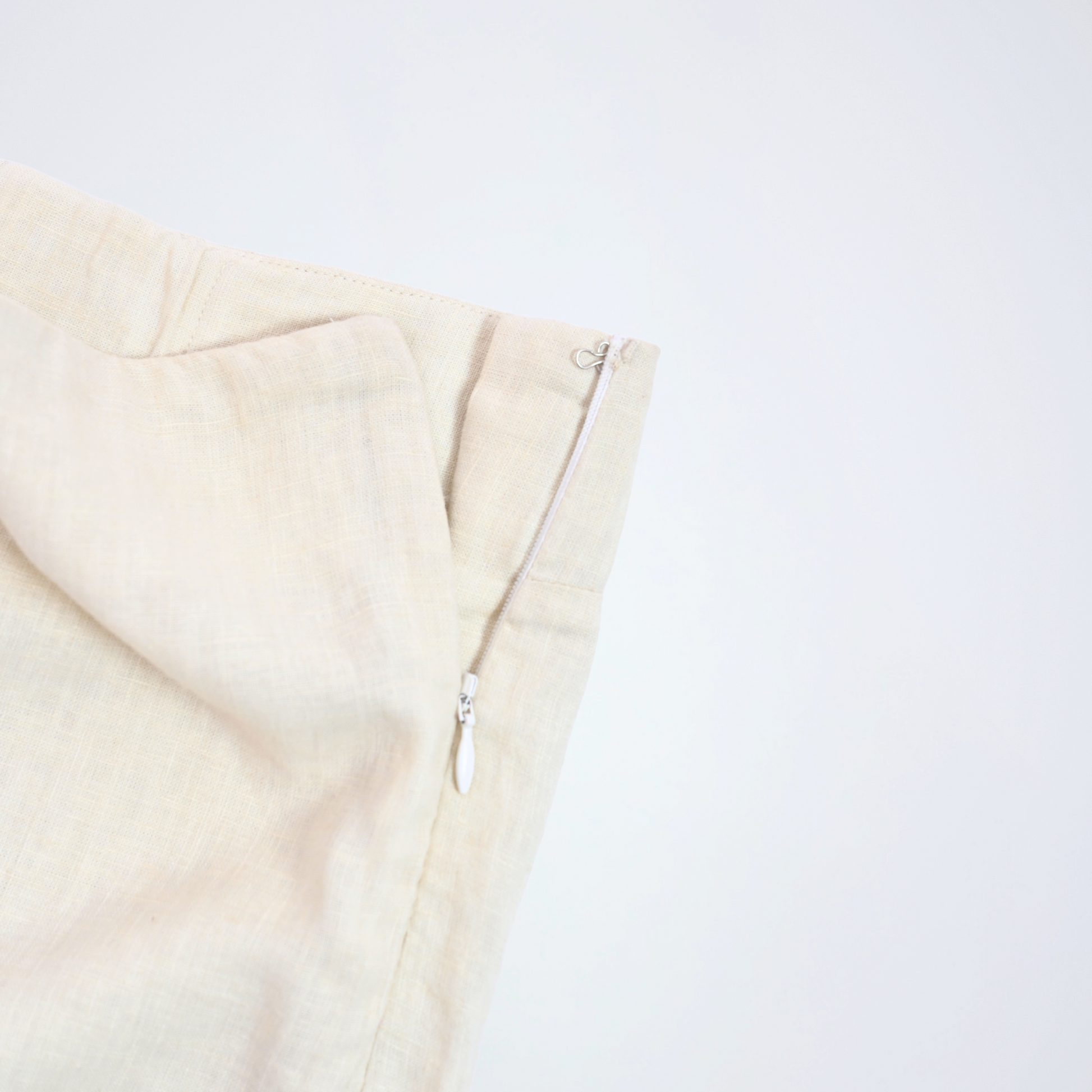 Pearl white linen shorts with crisp structure and side-zip. Breathable, mid-rise, and versatile, it adapts to your day