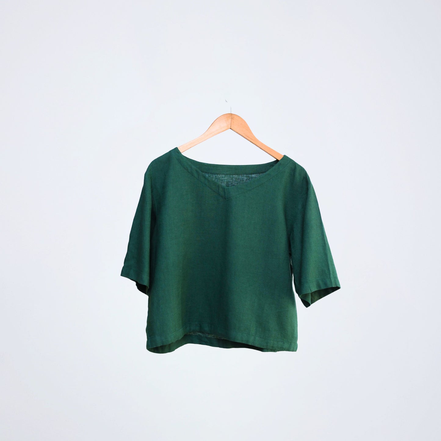 Breathable linen top with elbow-length sleeves. Relaxed fit for long days, in emerald tone - made for different settings