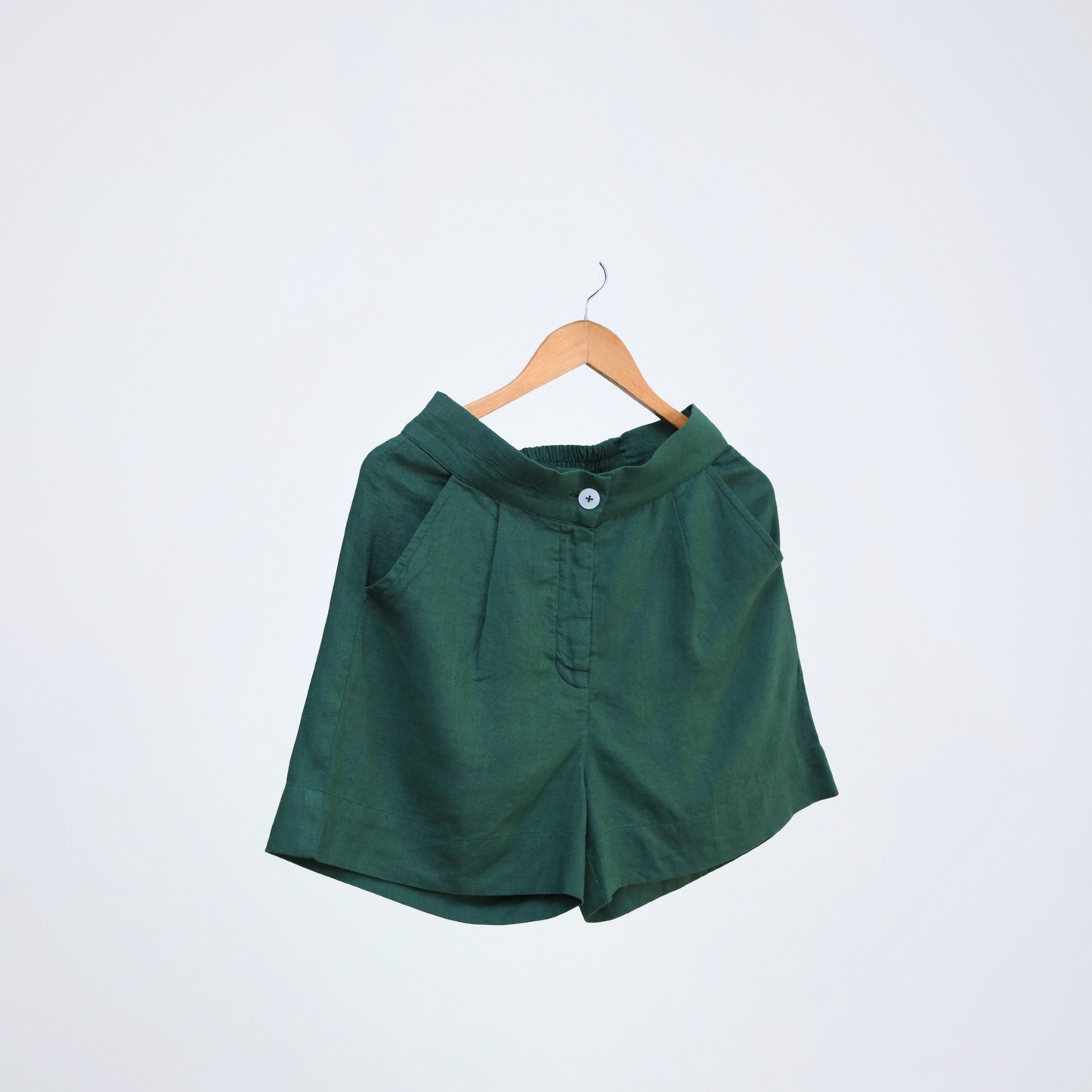 Emerald green linen shorts with a stretch back waist. Breathable, high-rise, and easy to pair for everyday versatility