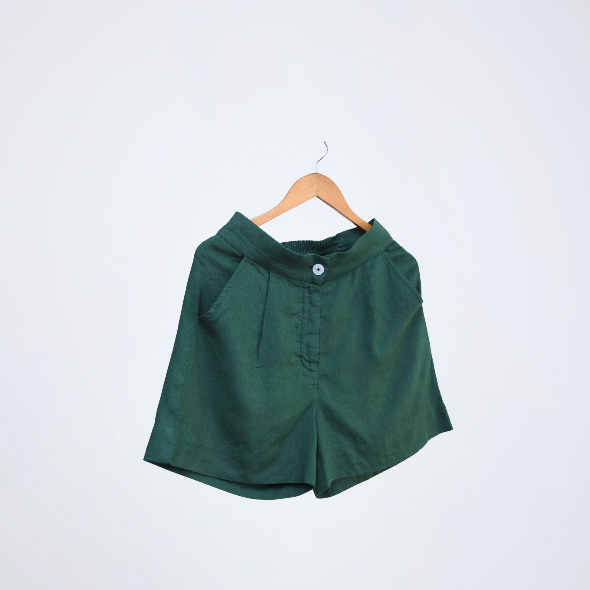Emerald green linen shorts with a stretch back waist. Breathable, high-rise, and easy to pair for everyday versatility