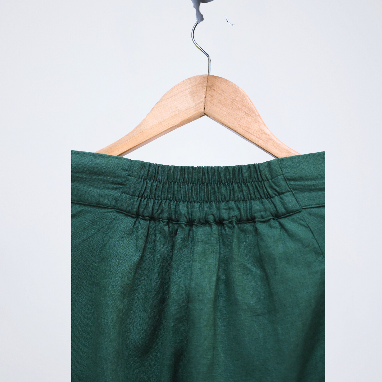 Emerald green linen shorts with a stretch back waist. Breathable, high-rise, and easy to pair for everyday versatility