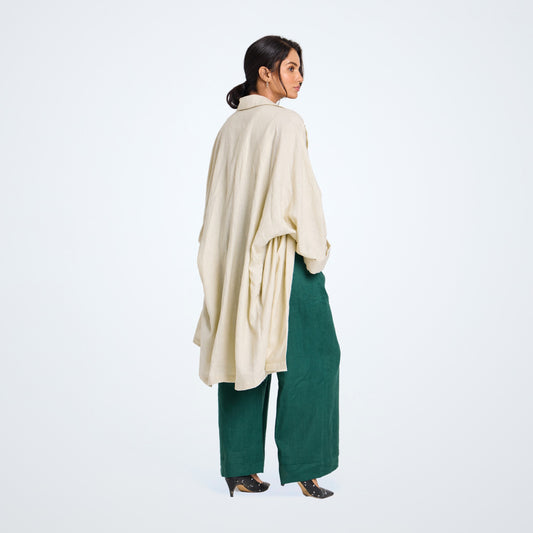 Long pearl white linen shrug with lapel collar and a button. Breathable, flowing, and versatile for no-effort layering
