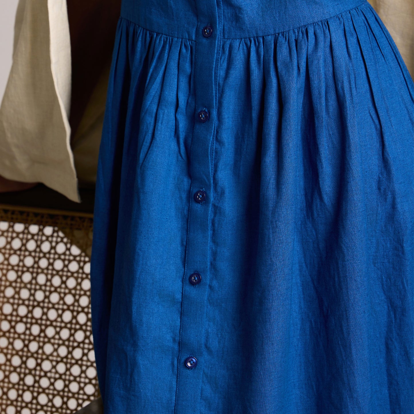 Sleeveless button-front linen midi dress with A-line fall. Breathable, airy, and effortlessly grounded for your days