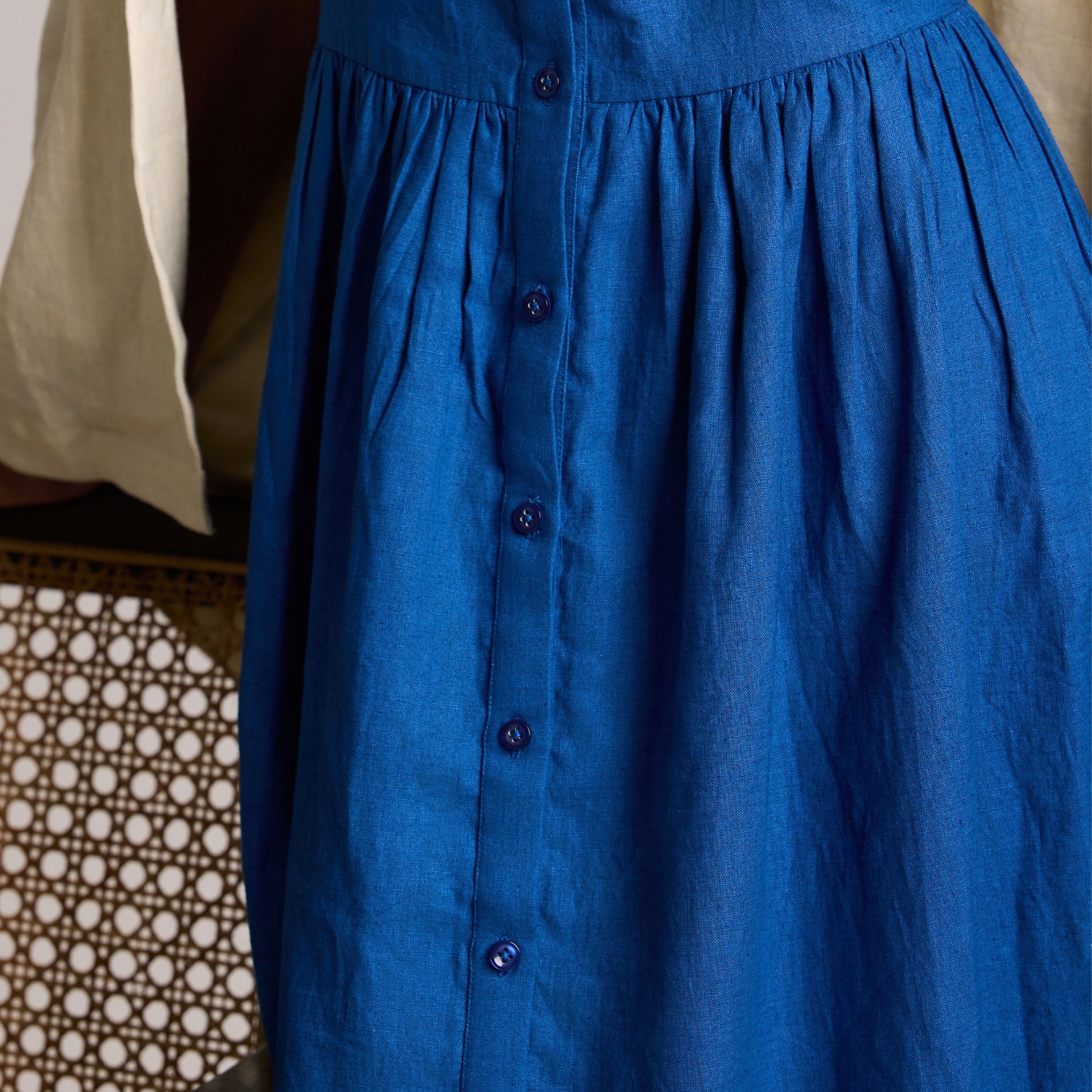Sleeveless button-front linen midi dress with A-line fall. Breathable, airy, and effortlessly grounded for your days