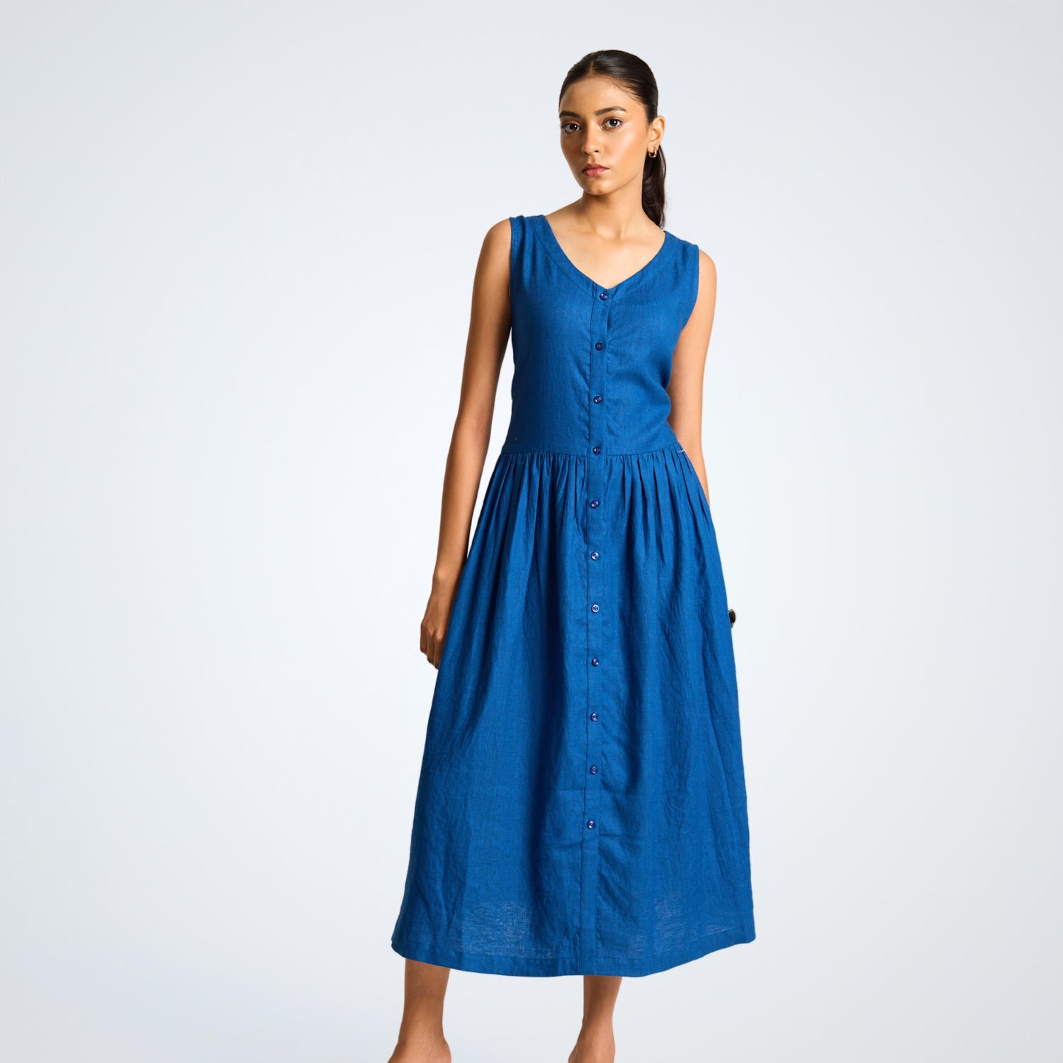 Sleeveless button-front linen midi dress with A-line fall. Breathable, airy, and effortlessly grounded for your days