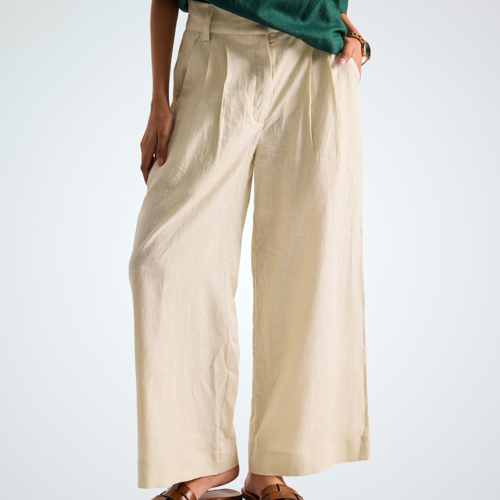 Pearl white linen pants with soft pleats and a stretch waist. Lightweight, breathable, and roomy for comfort and movement