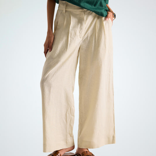 Pearl white linen pants with soft pleats and a stretch waist. Lightweight, breathable, and roomy for comfort and movement