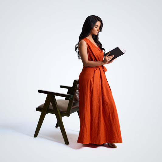 Sleeveless linen dress with pleated wrap fall. Breathable, relaxed, and fluid for moving forward with ease