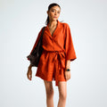 Relaxed orange rust linen playsuit with ¾ sleeves, roomy shorts, and a belt. Breathable comfort and effortless movement for any day | Selfish Clarity